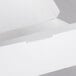 A white paper sandwich clamshell container with a lid open.