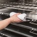 A person using a white towel to clean a Vulcan natural gas combi oven.