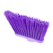 A close-up of a Carlisle purple broom head with long, unflagged bristles.