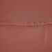 A close up of a mauve cloth table cover with a hemmed edge.