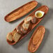 An American Metalcraft wooden oblong boat filled with bread slices and sauce.