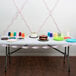 A table with a cake and plates on it with Classic Pink Streamer paper on the table.