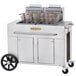 A Crown Verity double tank outdoor fryer on a large stainless steel cart with baskets.