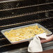French fries in a Thunder Group fully perforated bun pan on a counter.