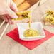 A hand pouring Spicy Asian Mustard into a small white bowl.