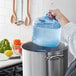 A person using a San Jamar Rapi-Kool rapid cooling paddle to pour water into a pot on the stove.