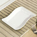 A CAC Soho ivory rectangular stoneware platter on a table with silverware.