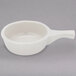 A Tuxton eggshell white bowl with a handle.