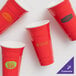 A group of red GET SC-32-R reusable plastic tumblers.