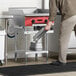 A man using a stainless steel equipment stand in a professional kitchen.