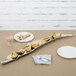 A nickel branch-shaped tray with food on a table.