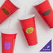 A group of red GET To-Go plastic cups with lids and straws.