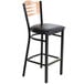 A wood chair back rest on a black chair.