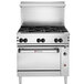 A stainless steel Wolf commercial range on a counter with black knobs.