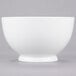 A white bowl with a white rim on a gray surface.