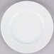 A white 10 Strawberry Street porcelain plate with a white rim on a gray surface.