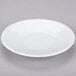 A white porcelain espresso cup and saucer on a white surface.