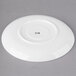 A white round porcelain saucer with black text that says "m"