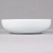 A white bowl on a grey surface.