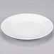 A white 10 Strawberry Street porcelain plate with a rim on a gray surface.