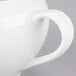 A close-up of a white 10 Strawberry Street porcelain creamer with a handle.