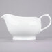 A white porcelain gravy boat.