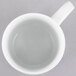 A 10 Strawberry Street Classic White porcelain mug with a small amount of liquid inside.