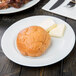 A 10 Strawberry Street white porcelain bread and butter plate with a piece of bread and butter on it.