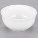 A white 10 Strawberry Street small oval porcelain rice bowl on a gray surface.