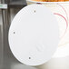 A white circular Solo lid with holes.