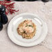 A Carlisle bone melamine plate with rice and chicken on a marble table.