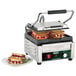 A Waring panini grill with two sandwiches cooking on it.