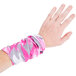 A hand with a pink and white camo Headsweats headband.