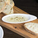 A white porcelain dish with a piece of bread on it.