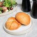 A Chef & Sommelier Geode stoneware plate with bread and salad on a table.