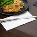 A plate of food with a 10 Strawberry Street stainless steel dinner knife on a napkin.