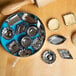 A blue bowl filled with Fox Run metal molds next to a rolling pin.