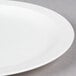 A close-up of a Carlisle white polycarbonate narrow rim plate.