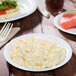 A Bare by Solo medium weight paper plate with macaroni and cheese and a watermelon slice on it.