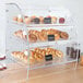 A Vollrath clear acrylic bakery display case with trays of pastries and cupcakes.