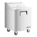 A white True refrigerated sandwich prep table with wheels.
