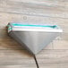 A metal triangle shaped Curtron insect trap wall sconce on a wood surface.