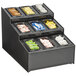 A black Vollrath 3 tier condiment organizer on a hotel buffet counter filled with different types of condiments.