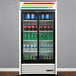 A True refrigerated glass door merchandiser with bottles of soda and water.