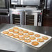 A MFG Tray eggshell fiberglass display tray holding cookies with candy on a counter.