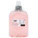 A plastic bottle of GOJO cranberry foaming hand soap with pink liquid inside.