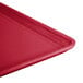 A close-up of a Cambro signal red fiberglass dietary tray with a plastic handle.