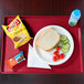 A plate of food with a sandwich, vegetables, and a bottle of water on a red Cambro dietary tray.