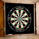 A Nodor dartboard with a dart in it on a wall.