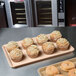 A MFG Tray bakery display tray of muffins on a counter.